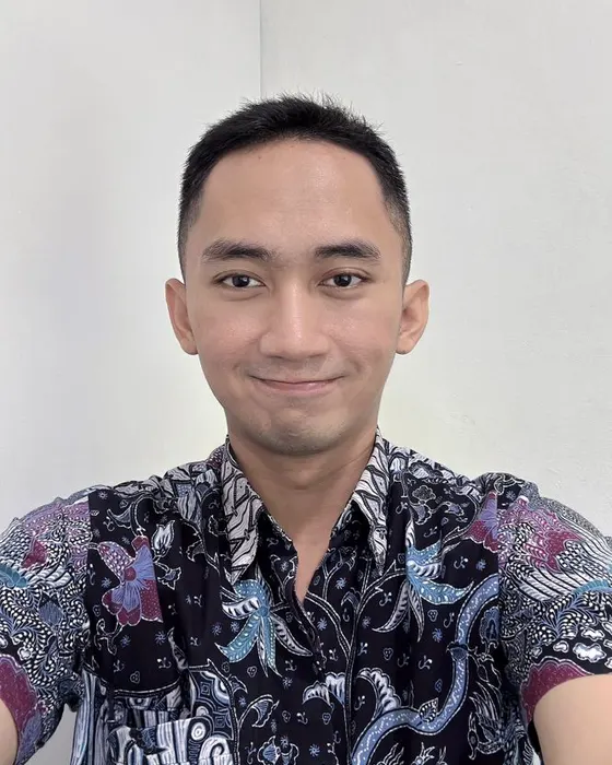 Alvin smiling in a colorful batik shirt